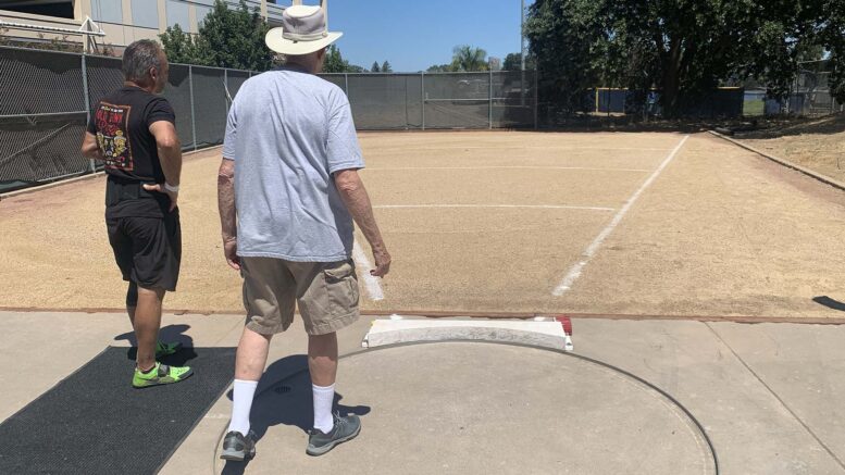 USATF field referee checks out shot put ring at American River College.